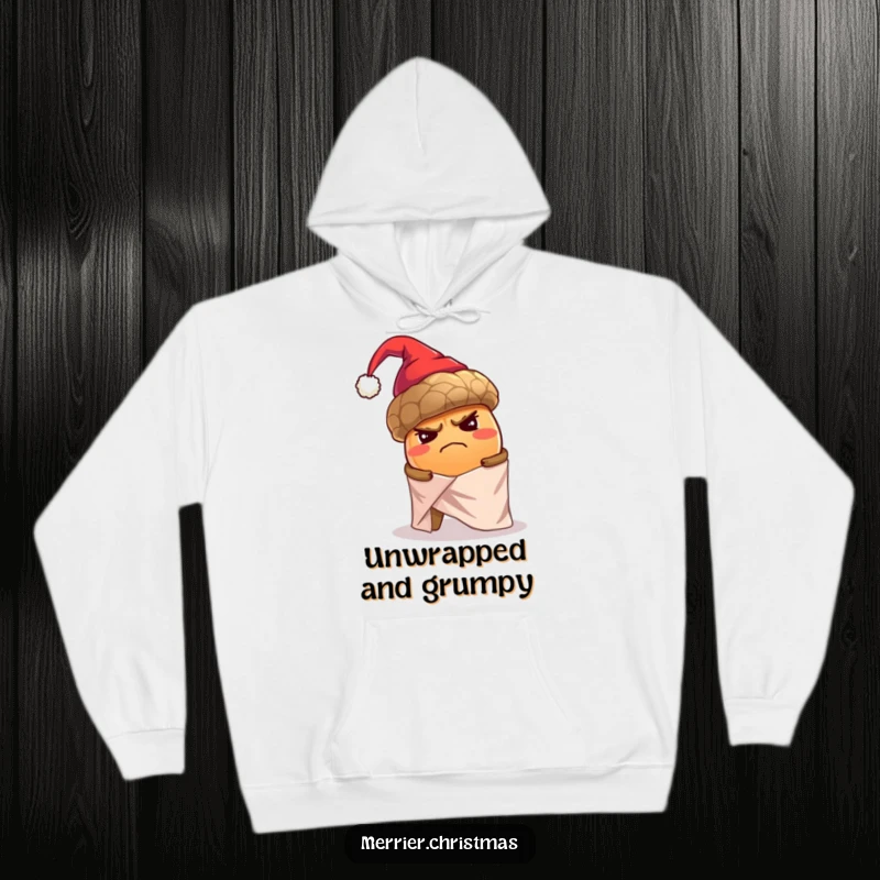 Funny hoodie featuring a grumpy, oversized acorn wearing a tiny Santa hat and struggling to wrap itself in shiny paper.